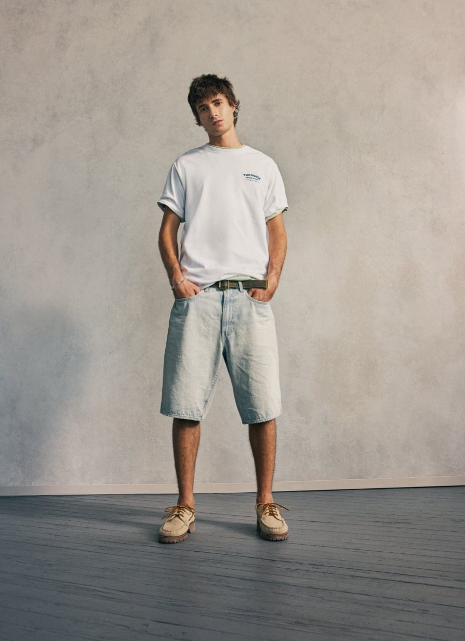 Model wearing a white t-shirt and denim shorts from Levi's Spring Summer 2026 collection.