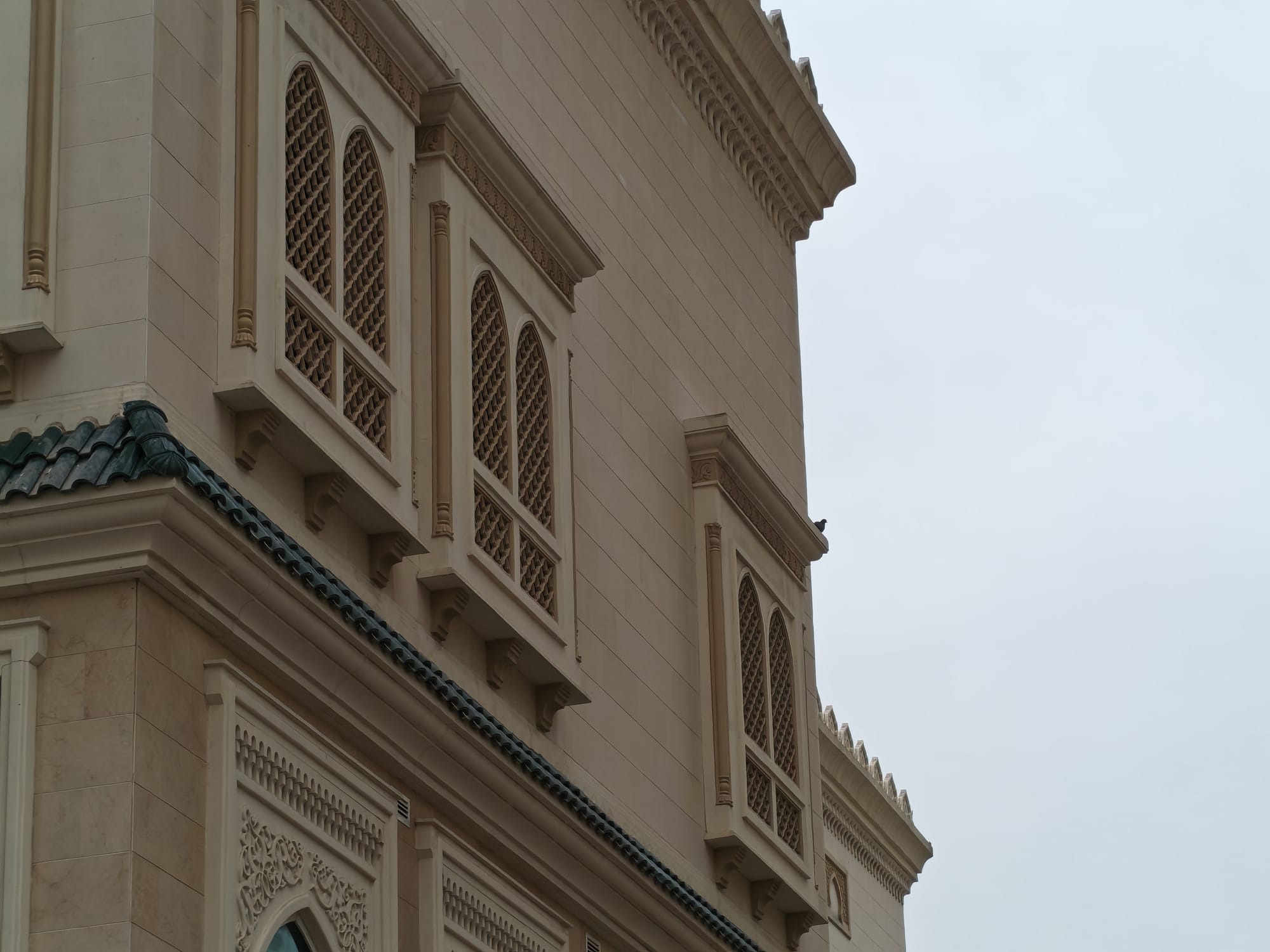 Honor 600 daylight camera sample: ornate beige building facade with arched lattice windows and decorative trim