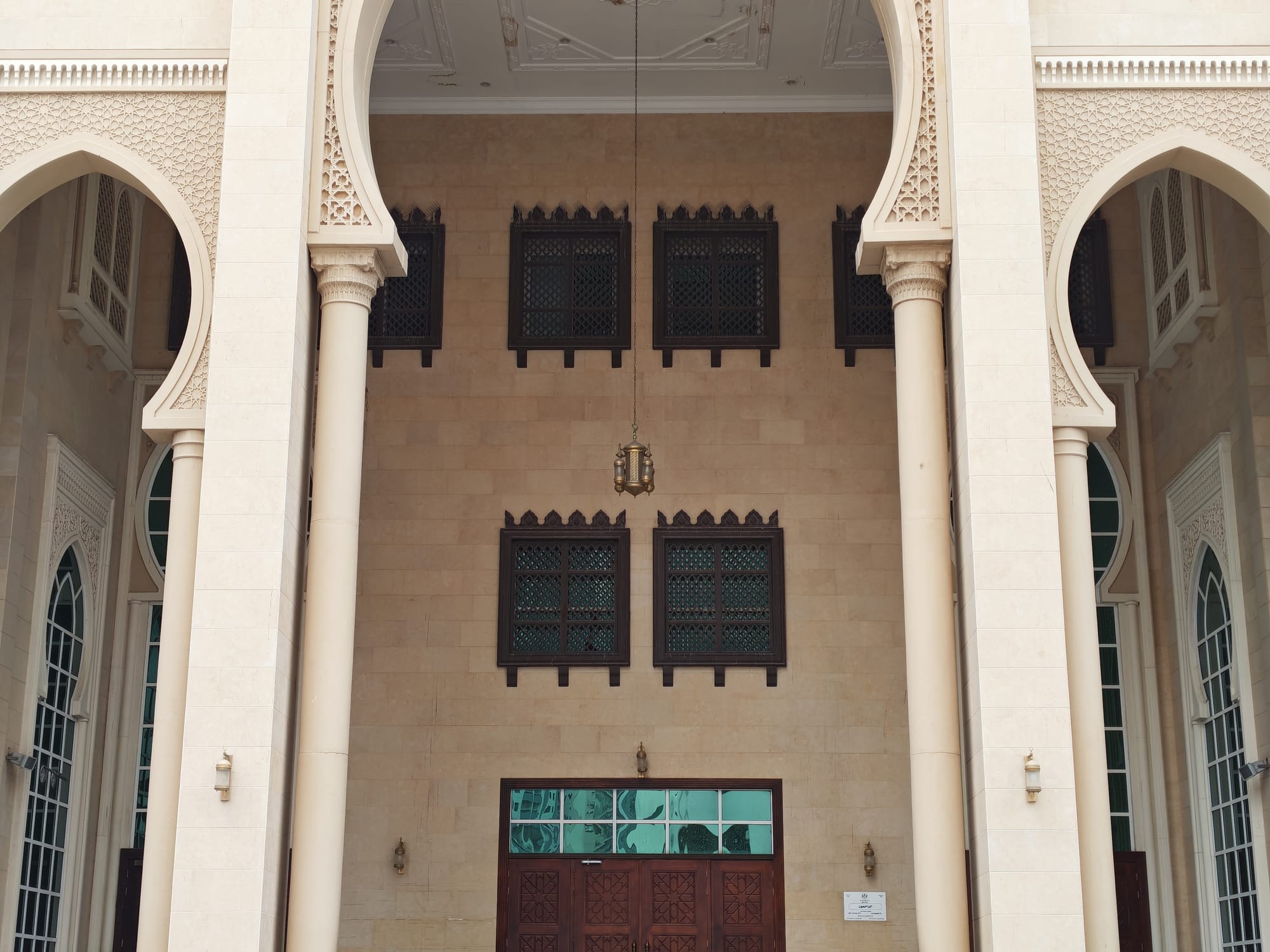Honor 600 daylight camera sample: mosque entrance with ornate columns, arched windows, and a hanging brass lamp