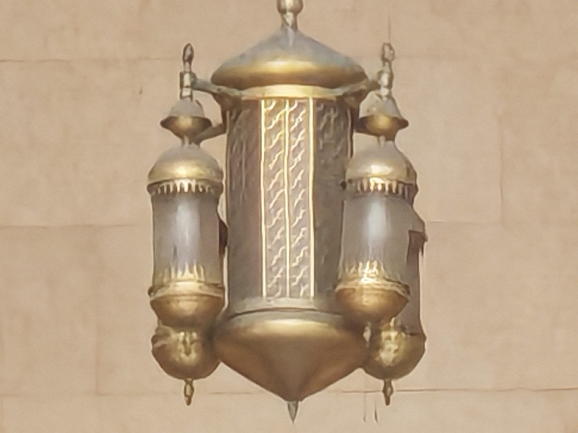 Honor 600 zoom camera sample: ornate brass mosque lamp with filigree detail mounted on a beige stone wall