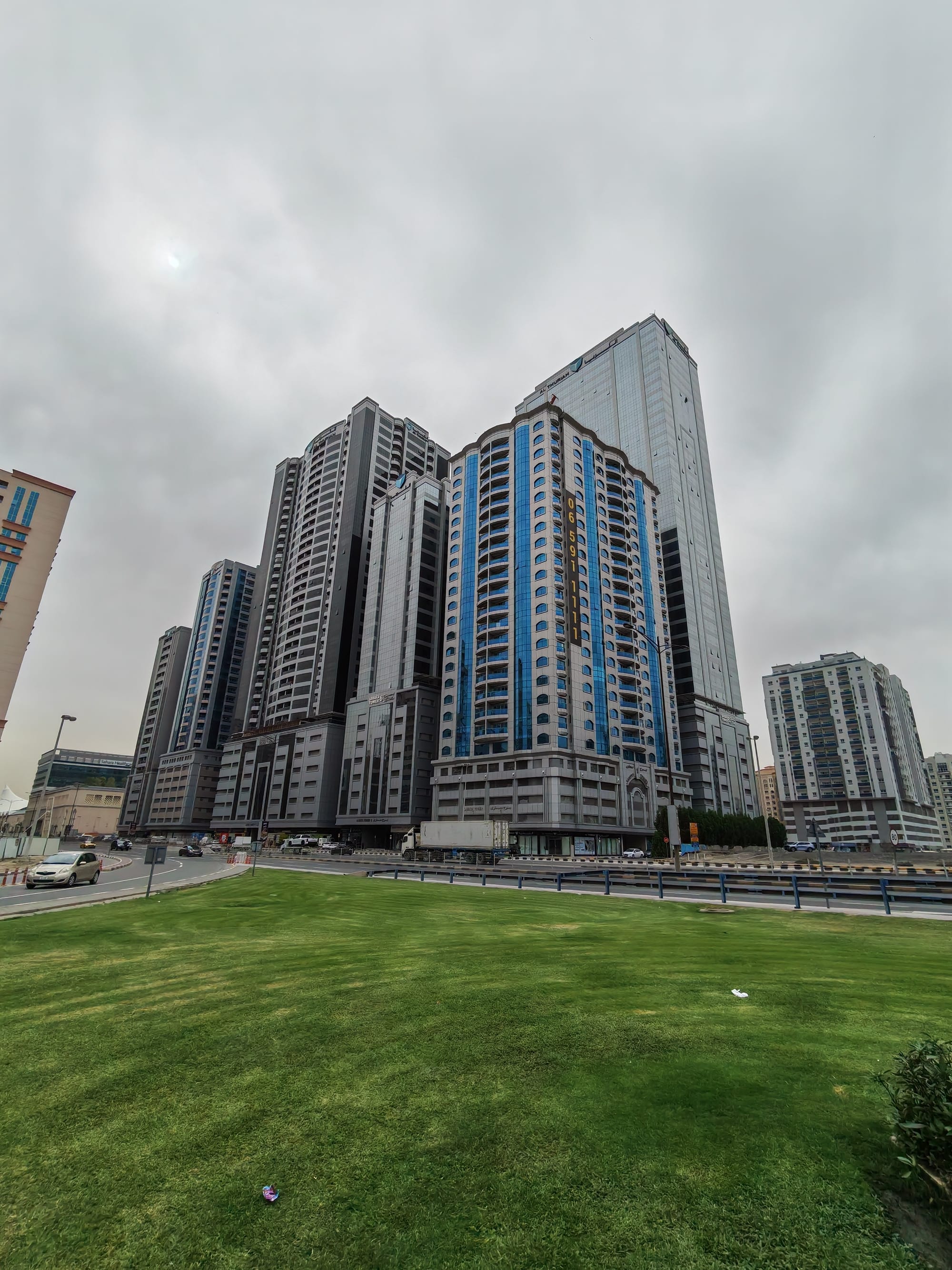 Honor 600 ultrawide camera sample: Sharjah high-rise apartments and an office tower viewed across an open lawn