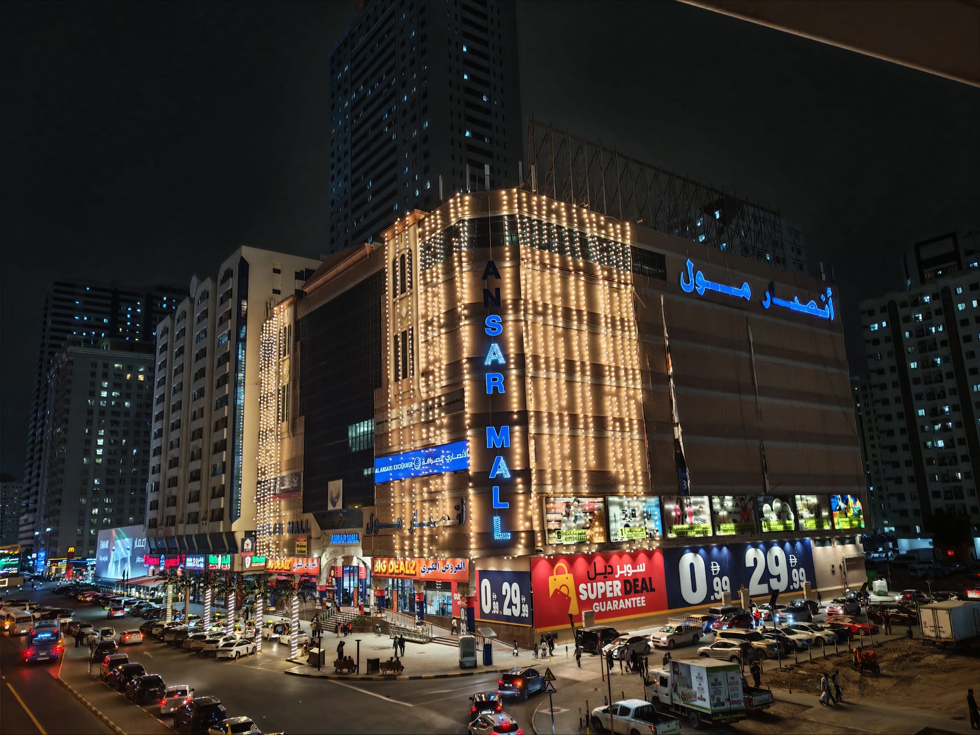 Honor 600 night camera sample: Ansar Mall in Sharjah outlined in fairy lights with bilingual signage and surrounding traffic