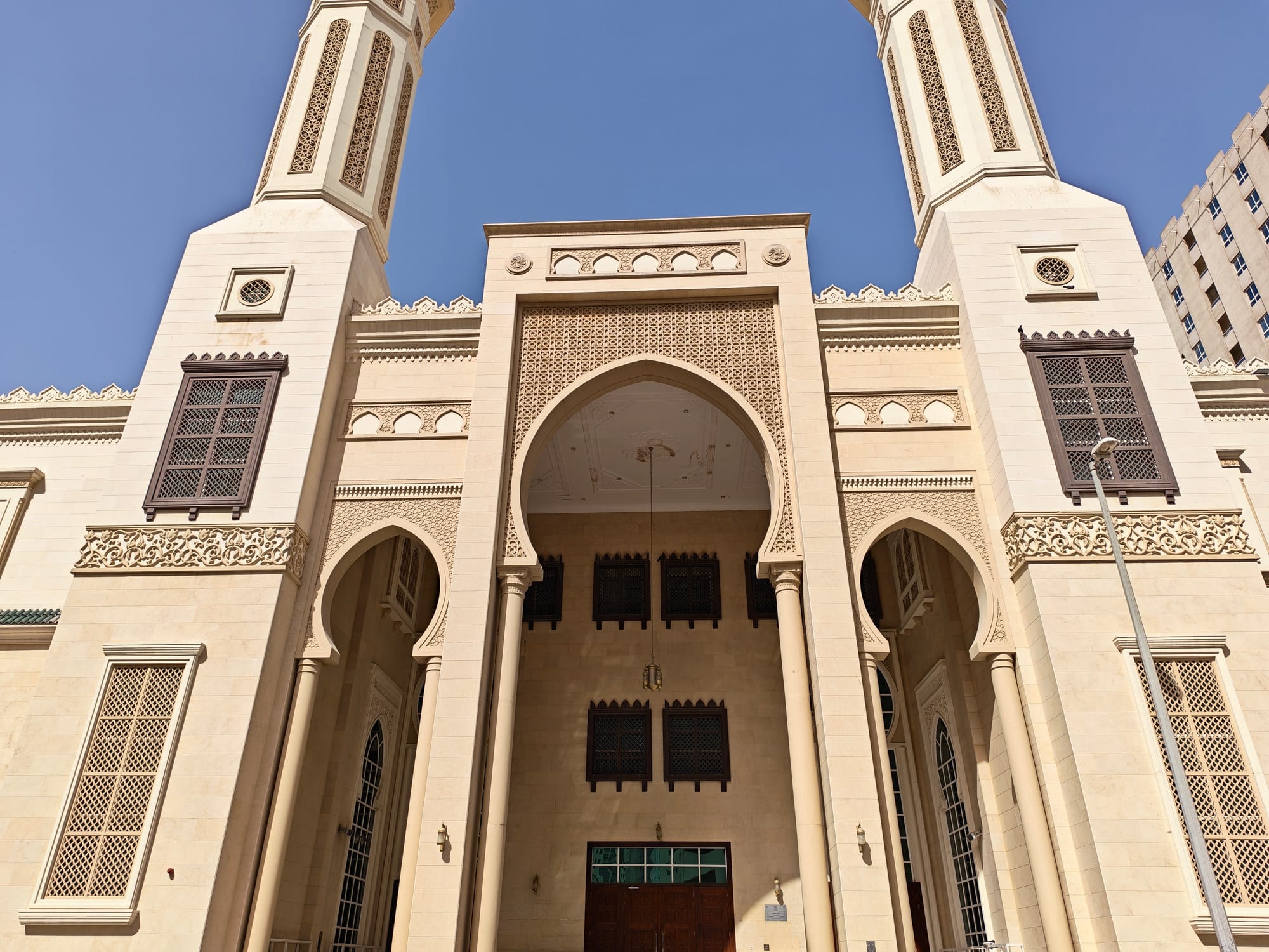 Facade of a mosque featuring grand entrance and detailed ornamentation.