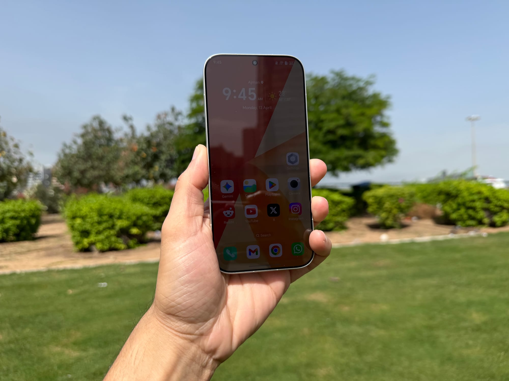 Honor 600 Pro held vertically against a clear sky with app icons displayed on the screen.