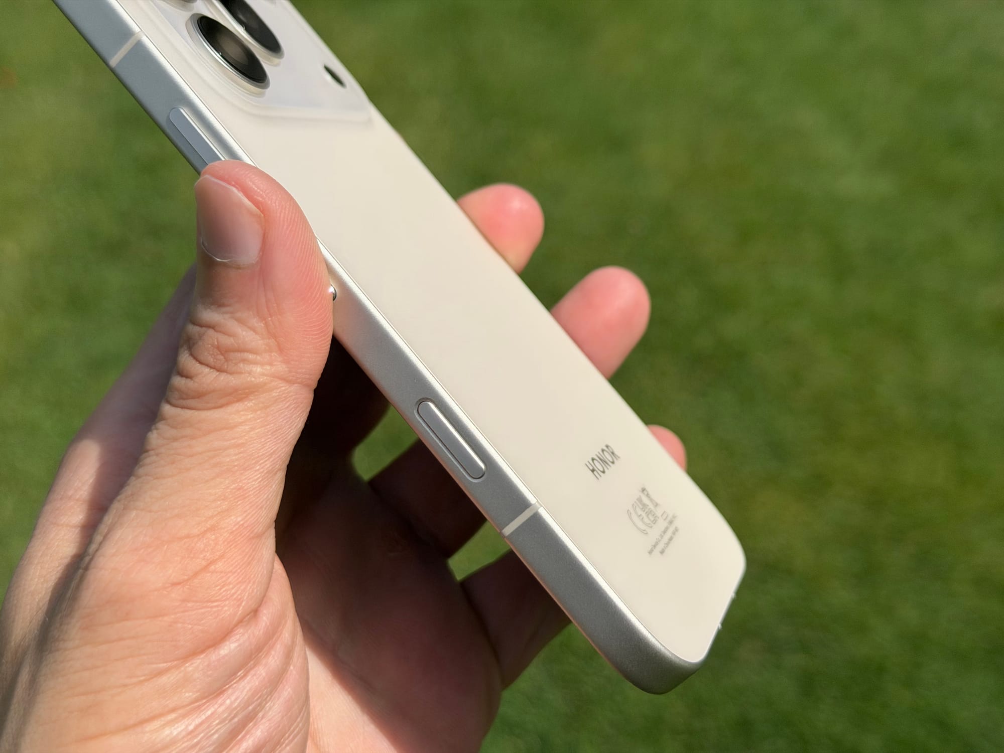 User holding Honor 600 Pro, displaying the phone's side buttons and sleek finish.