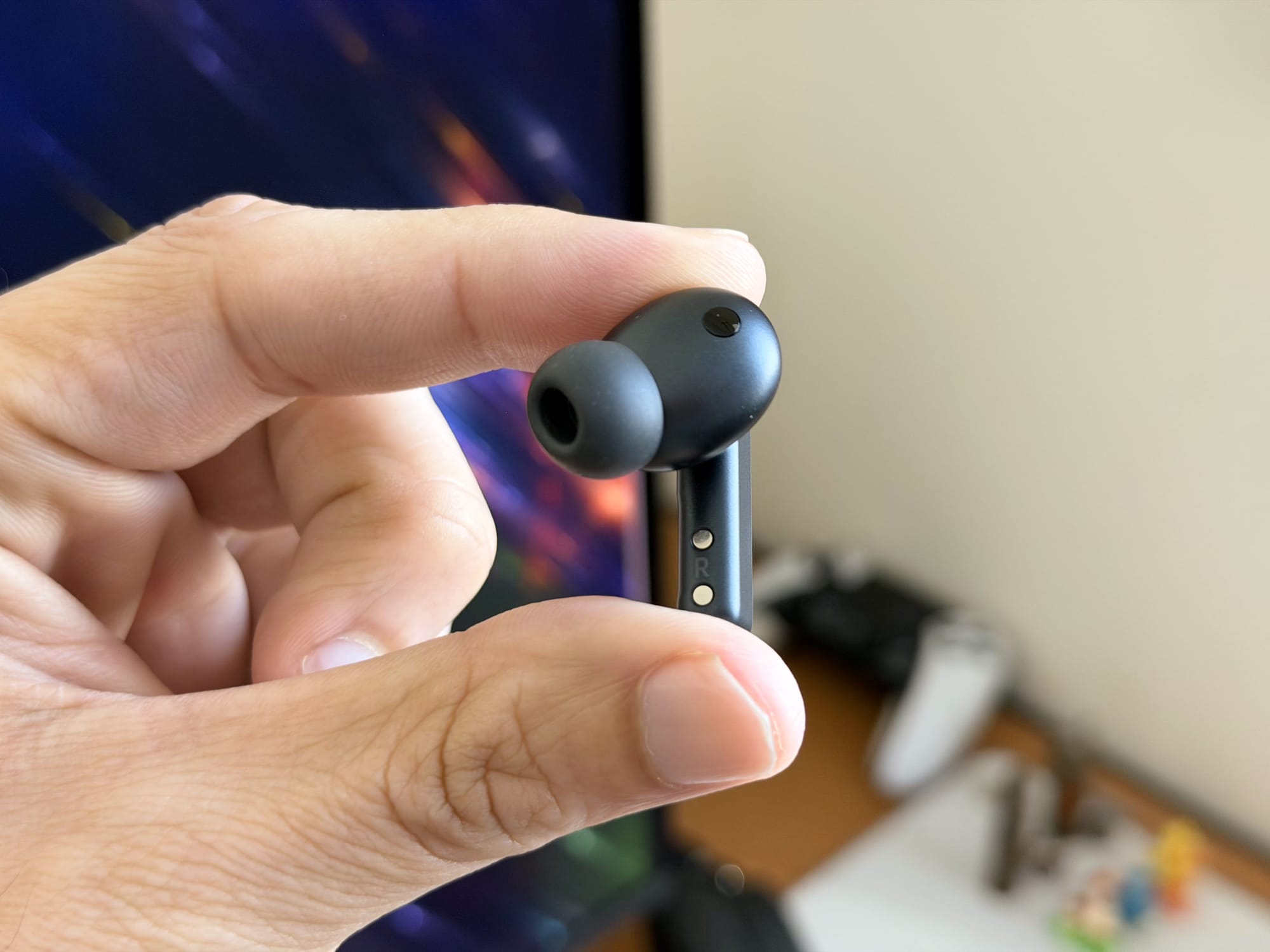 Close-up view of a Samsung Galaxy Buds4 Pro earbud held between fingers.