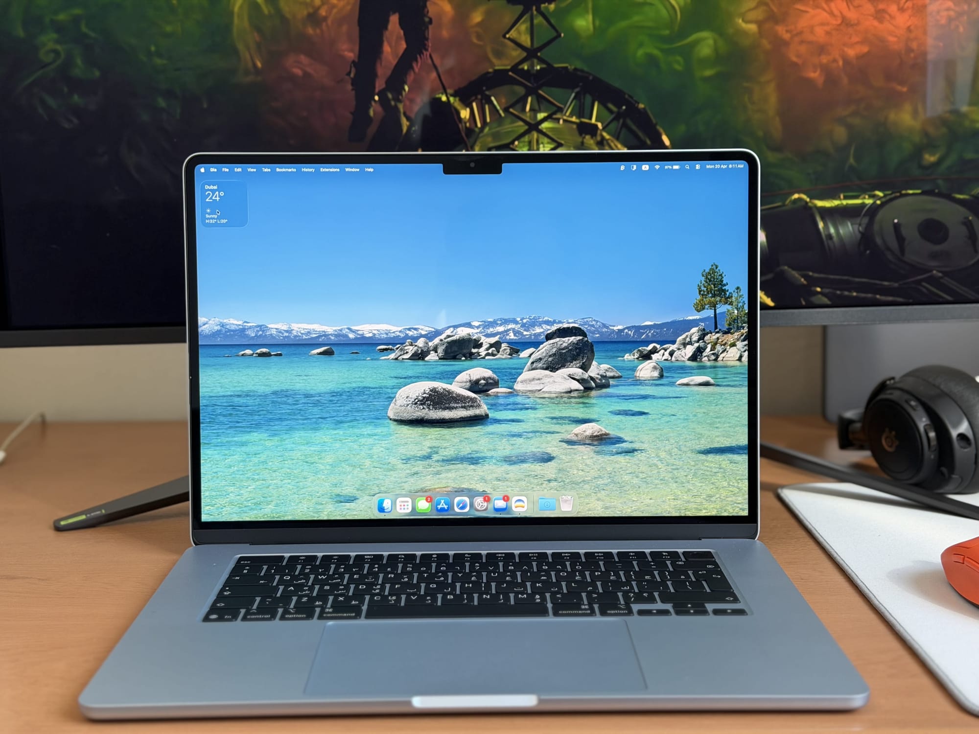 Display of the MacBook Air 15” featuring a scenic lake wallpaper with rocky shore.