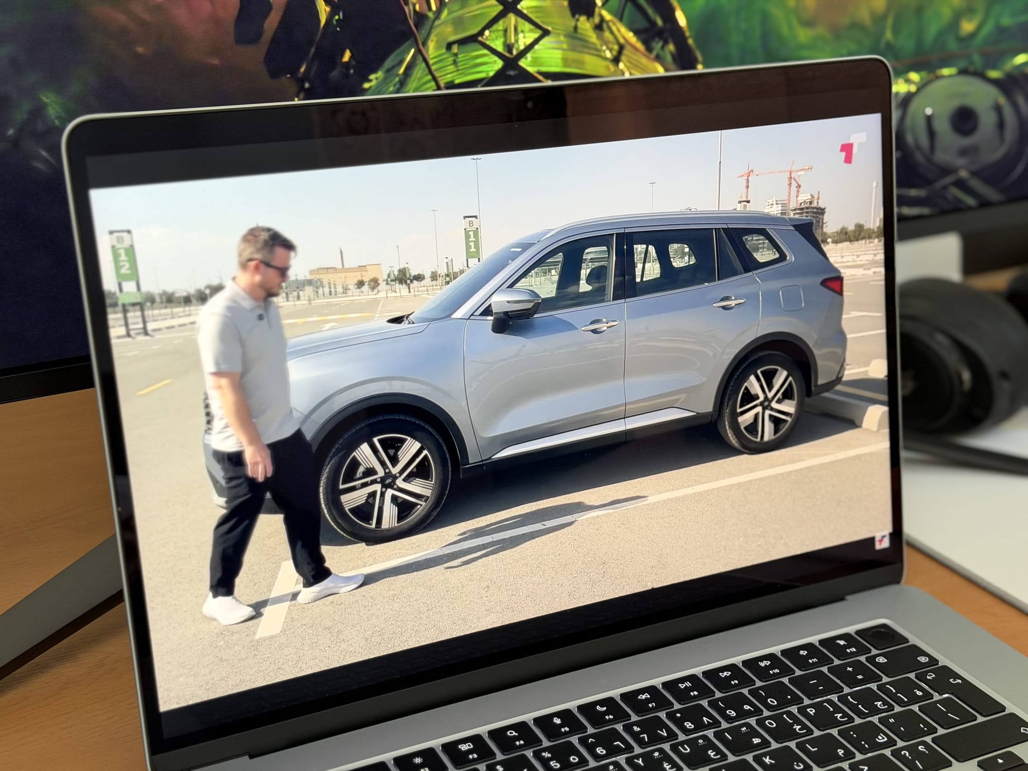 Screenshot on MacBook Air 15” showing a man walking by a silver SUV in a parking lot.