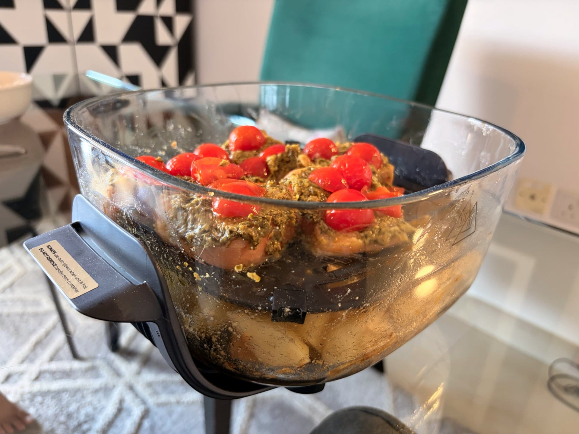 Cooked salmon with herbs and cherry tomatoes in Ninja Crispi, displayed in a glass bowl