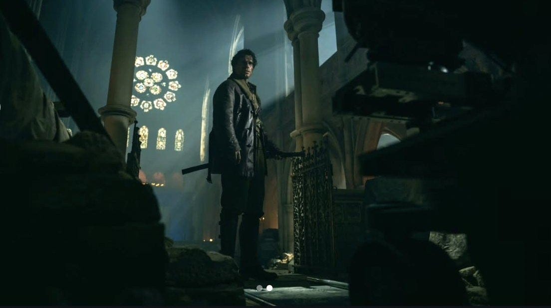 Henry Cavill in a dimly lit castle interior, gripping a sword, facing a large stained glass window.