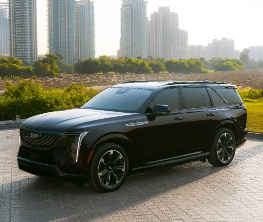Cadillac Escalade IQ showcased against a backdrop of city skyscrapers and greenery.