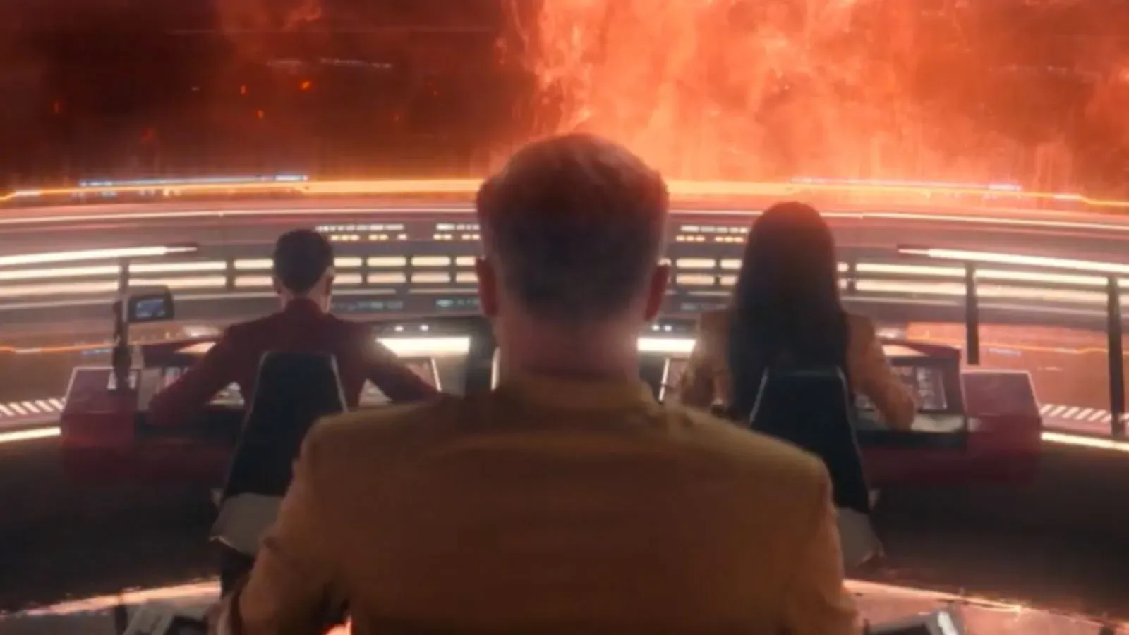 Rear view of crew members at the command console, facing a dramatic space phenomenon.