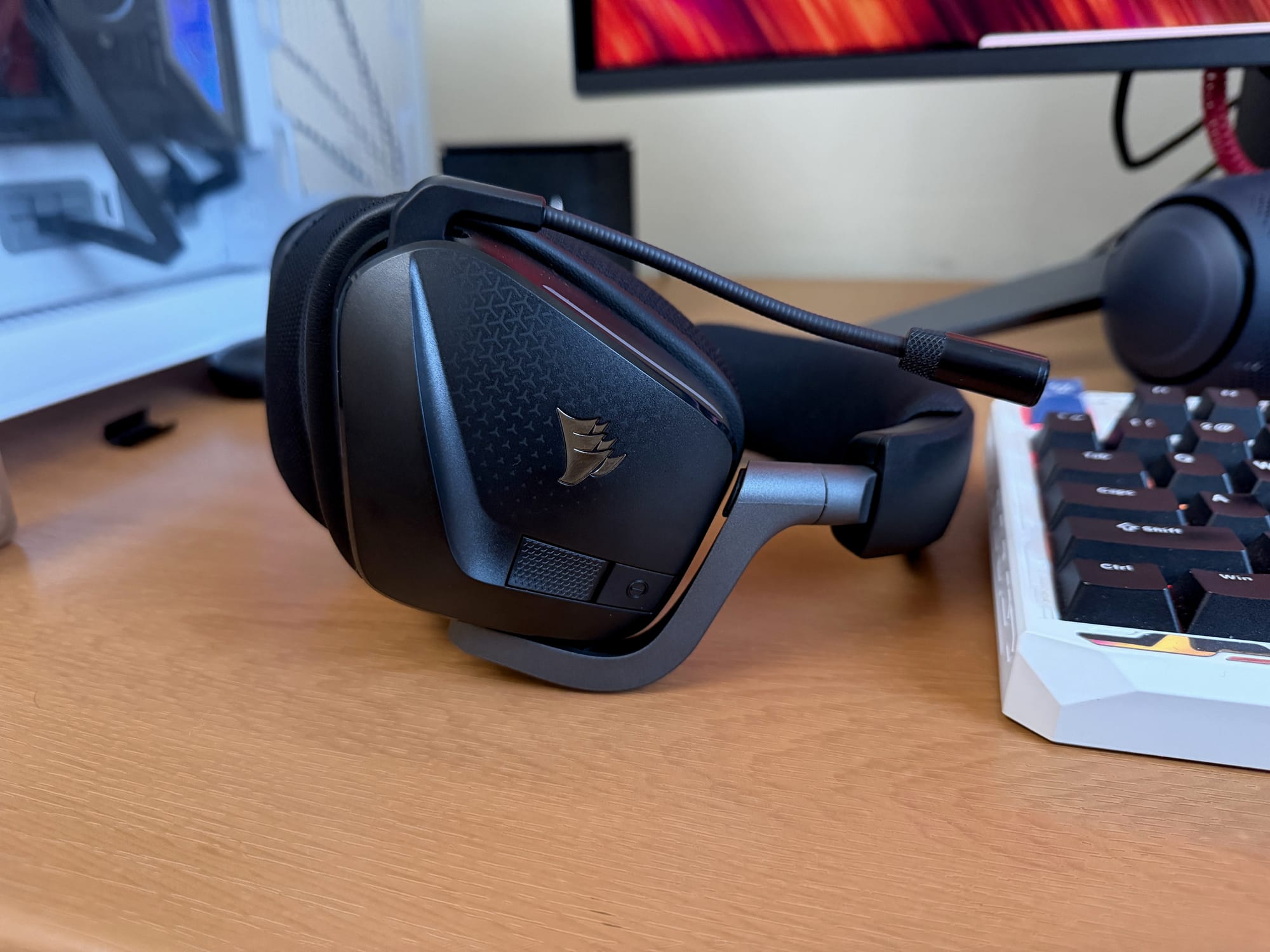 Corsair Void v2 MAX Wireless headset placed next to a keyboard on a desk.
