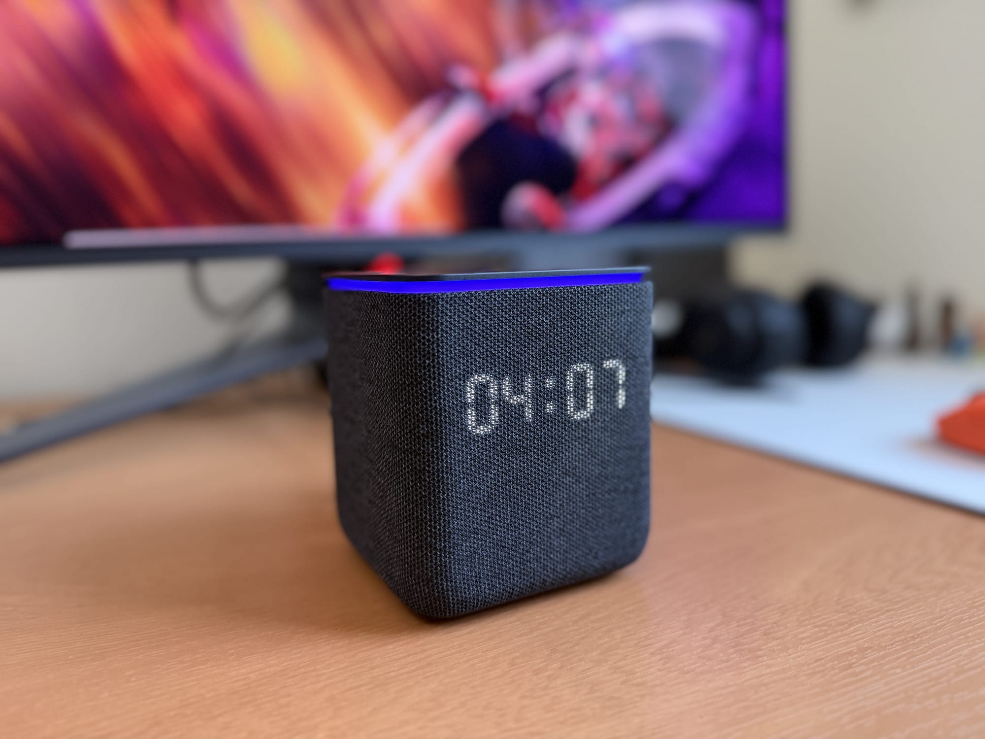 Yasmina Midi smart speaker displaying time on a desk.