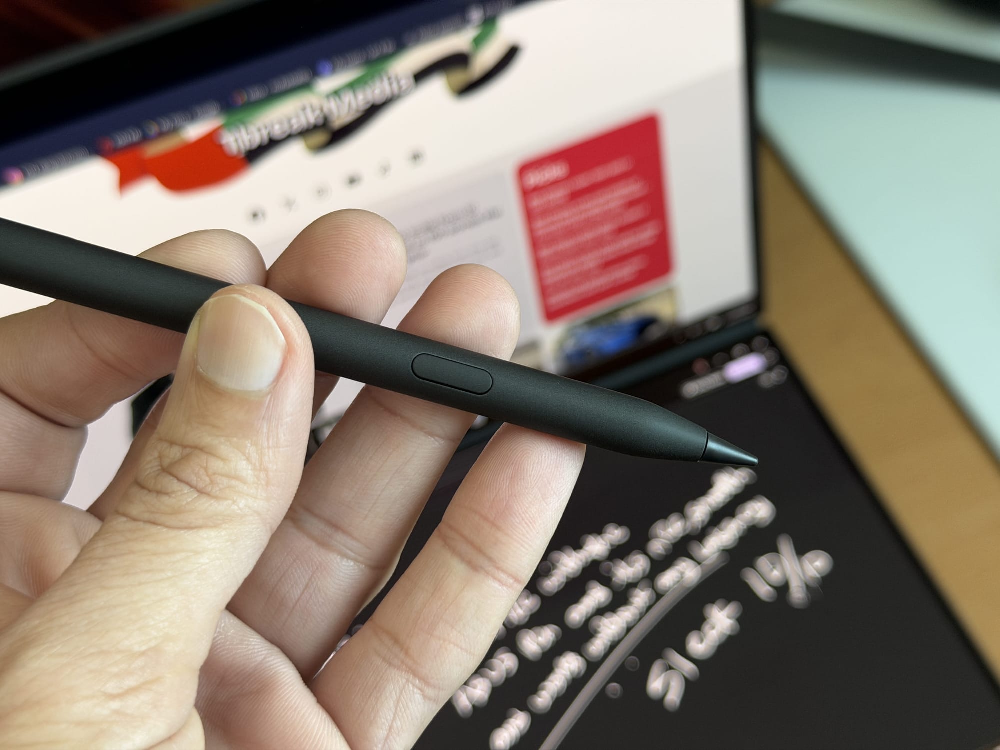 Close-up of a hand holding an Asus stylus above the ZenBook Duo's screen displaying handwritten notes.