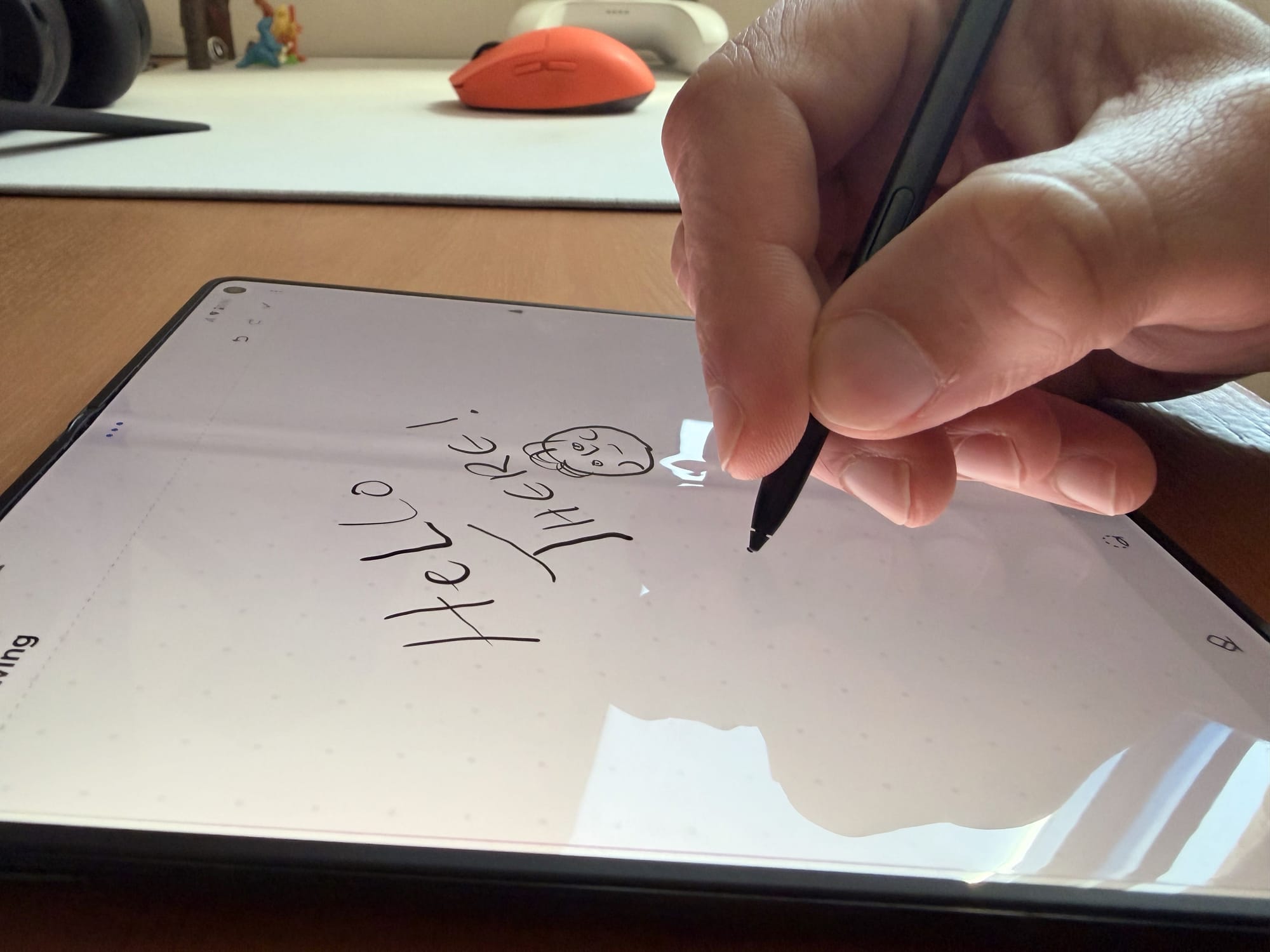 Hand using a stylus to write on the Motorola Razr's screen, with a note visible.