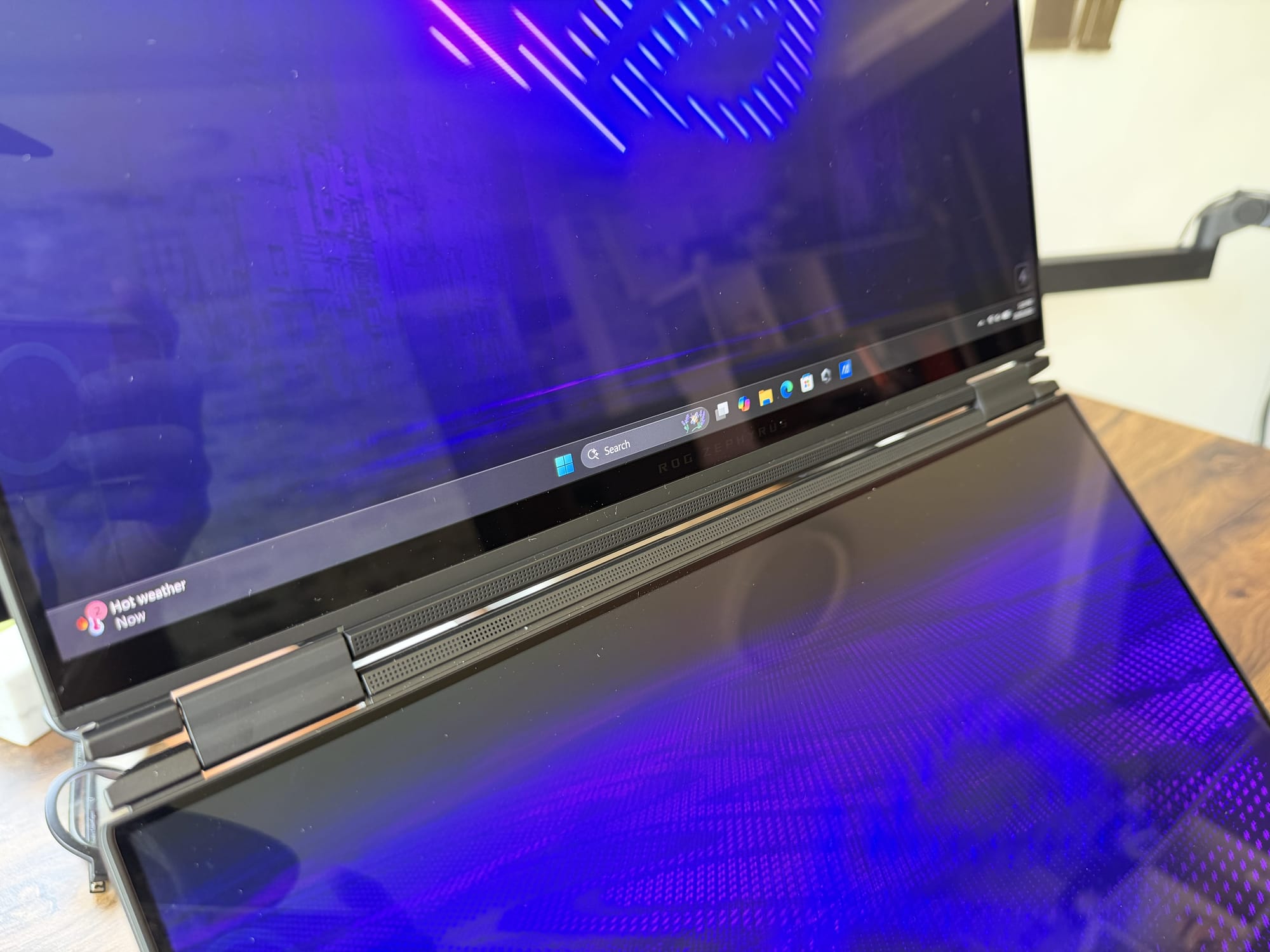 The glossy OLED panel reflecting ambient light from the room
