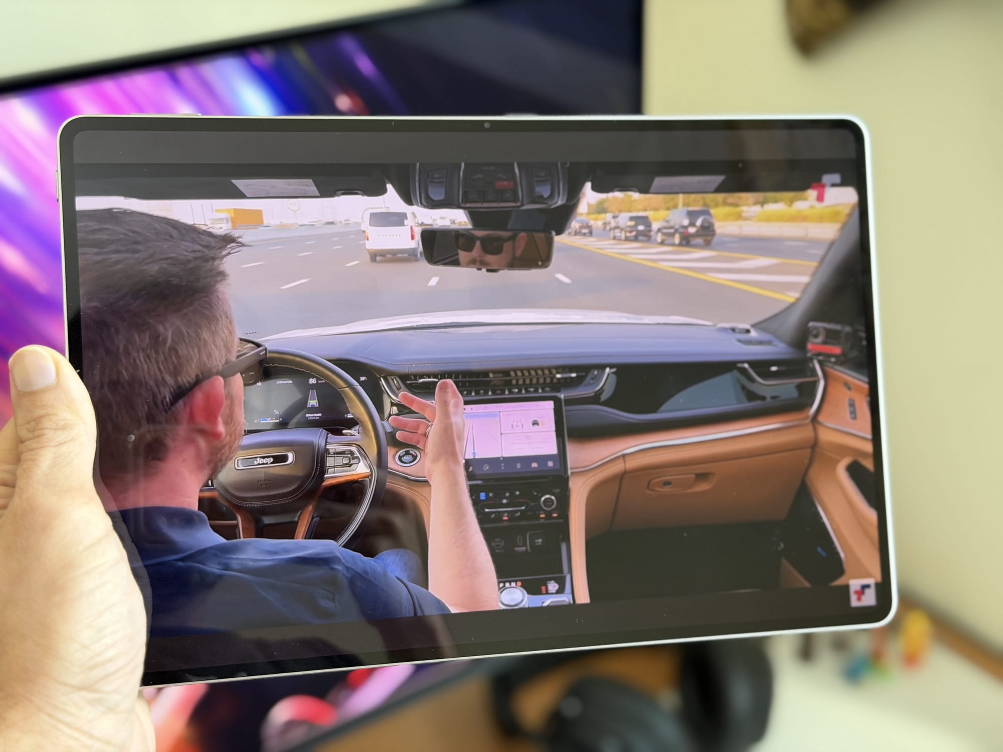 User holding Honor MagicPad 4 while watching a video in a car.