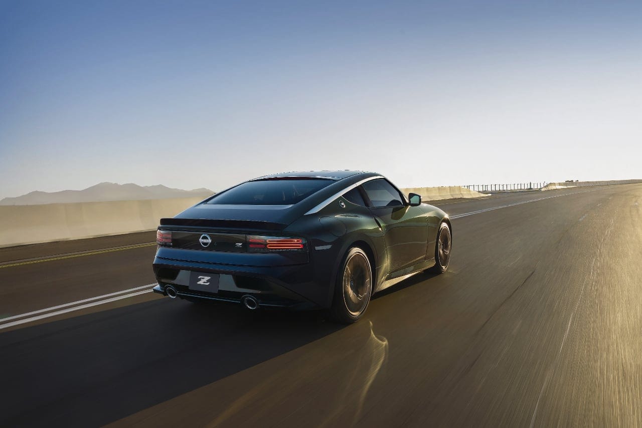 Nissan Z Heritage Edition driving on a winding road with mountains in the background.