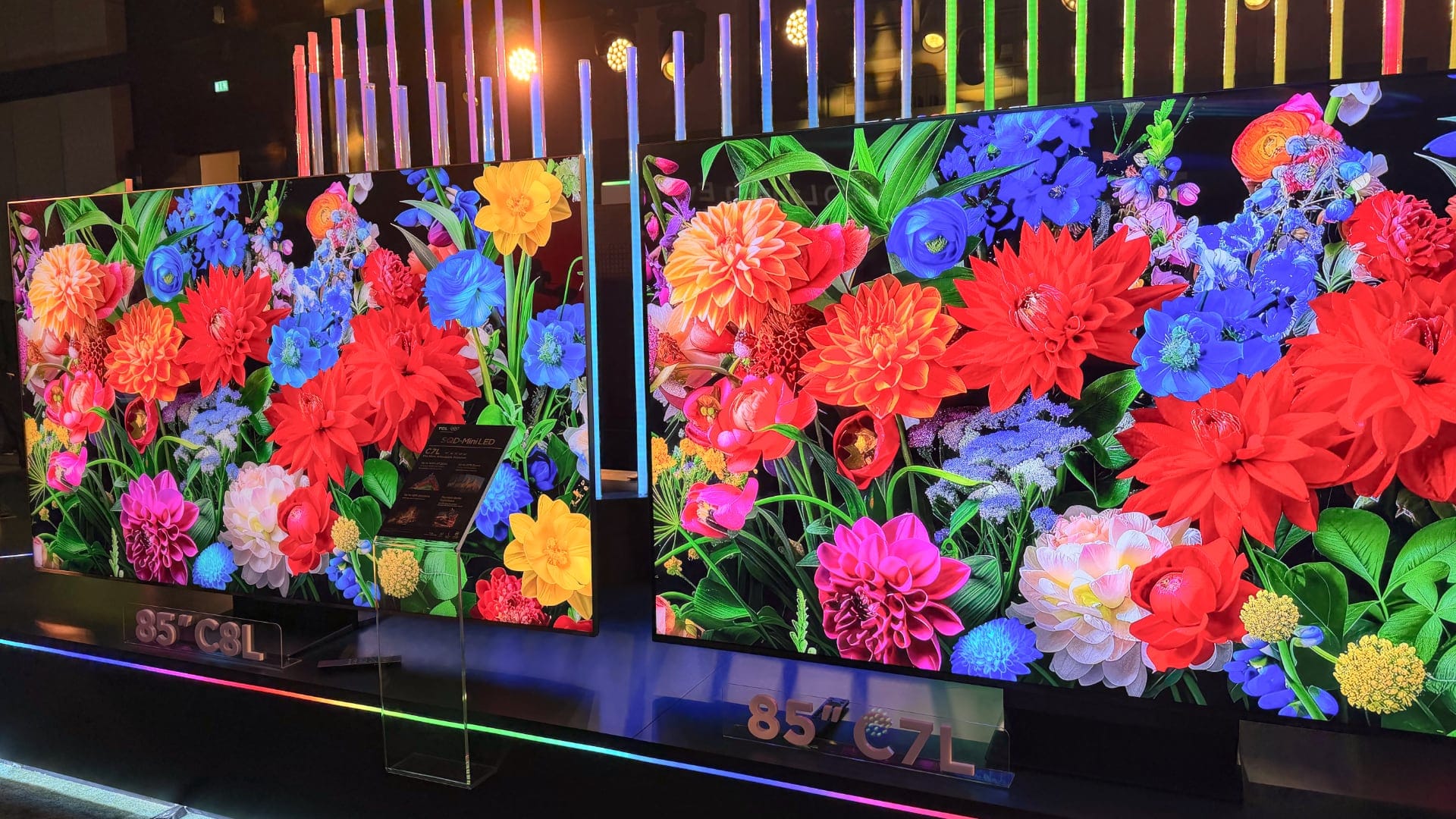 TCL 85-inch C8L and C7L on display side-by-side, both showing a vivid floral demo image.