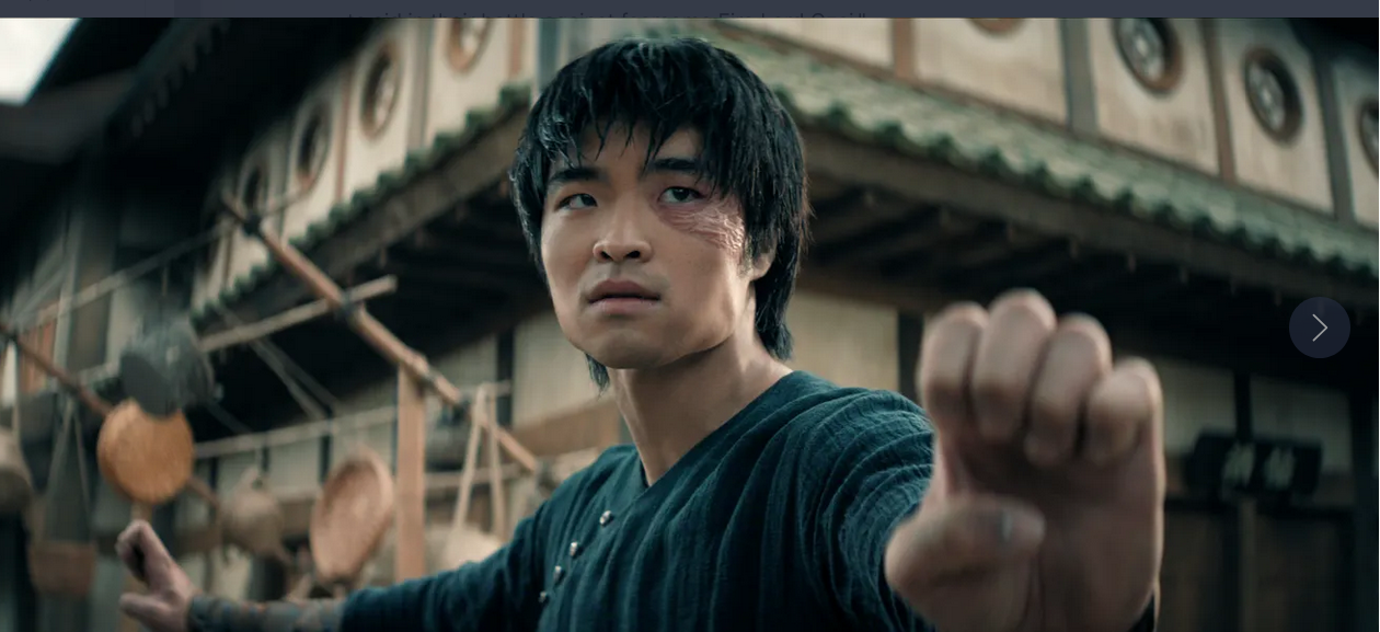 A character displays an intense focus, preparing for a fight in a rustic village.