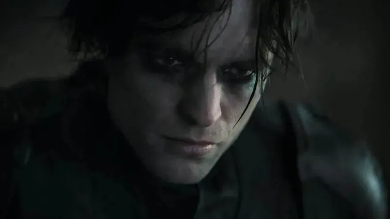 Intense close-up of Robert Pattinson as Batman, featuring dramatic makeup and damaged costume.