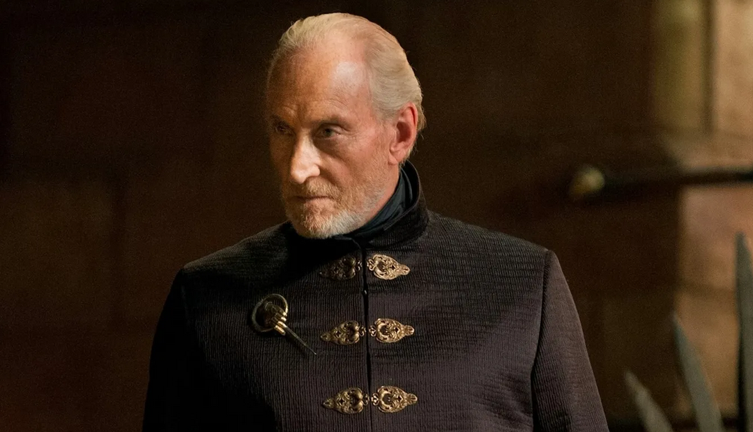 A regal-looking older man in an ornate black outfit, standing with a stern expression.