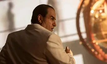 Colin Farrell's Penguin looking back dramatically, with shadows in the background.