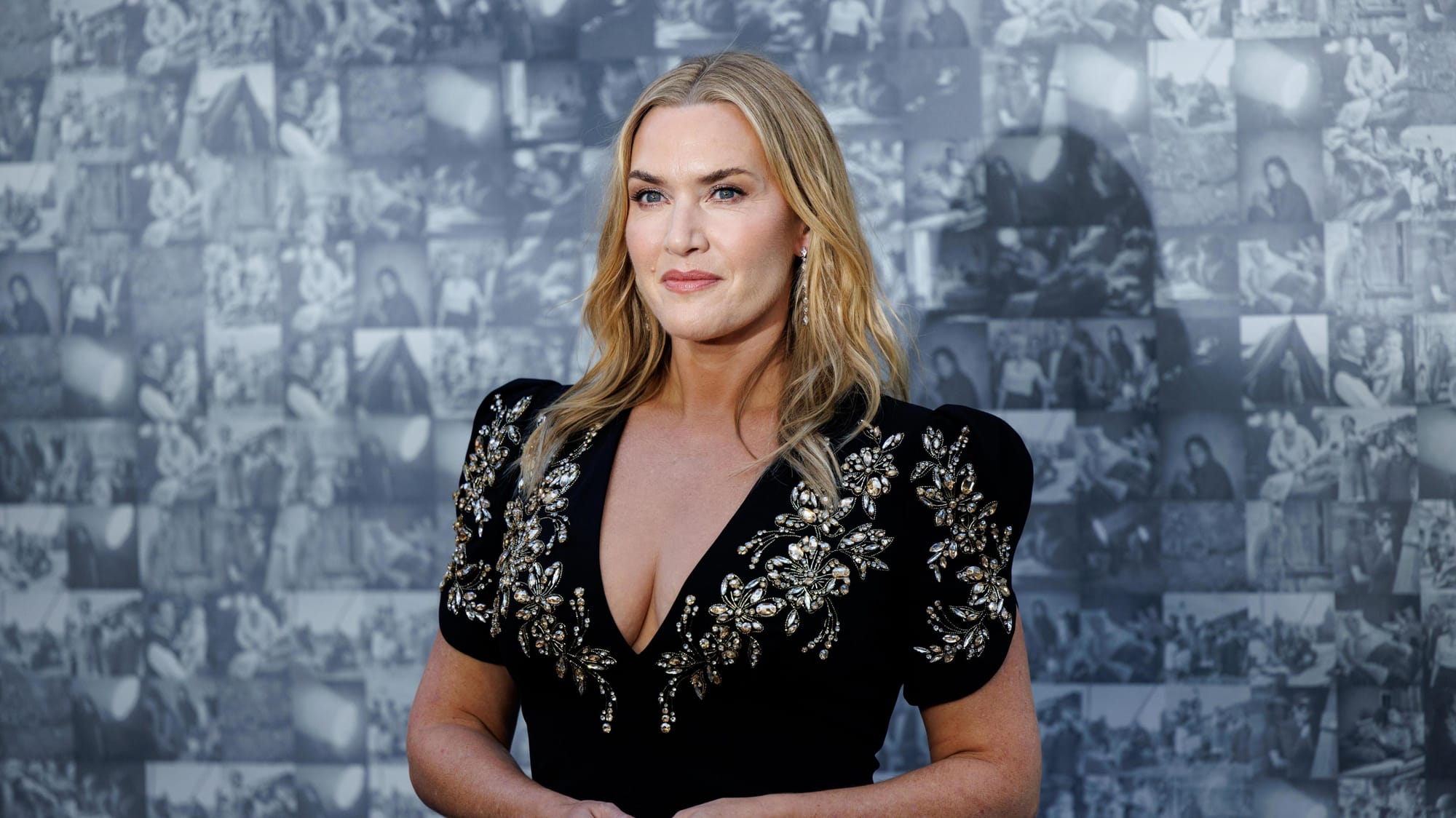 Kate Winslet wearing an elegant black dress with intricate floral embellishments.
