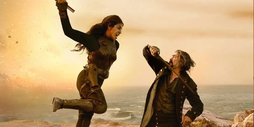 Intense action scene with a female fighter confronting a male opponent on a rocky shore.