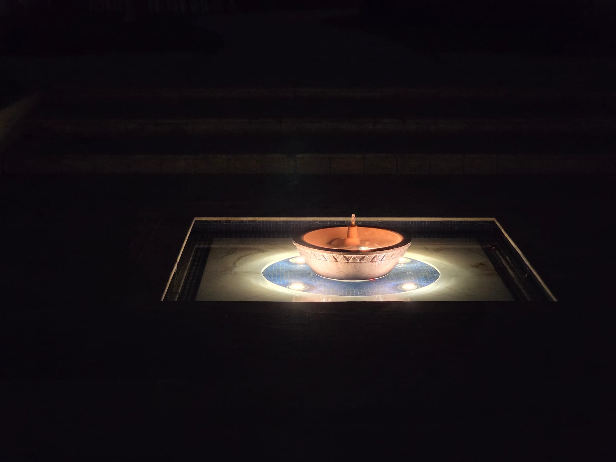 Illuminated fountain at night set in a courtyard