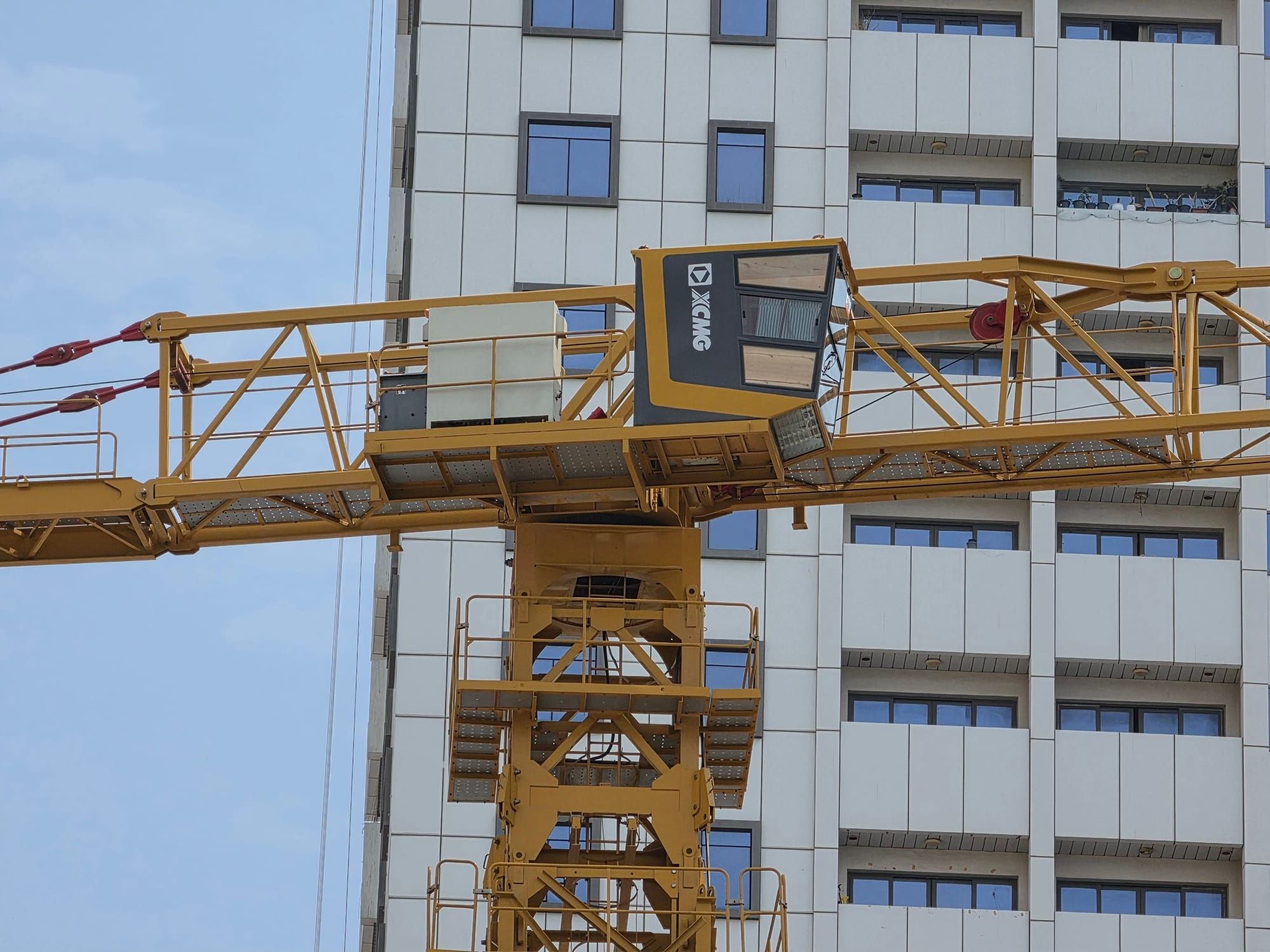 Close-up of a construction crane on a building site, with focus on operator's cabin.