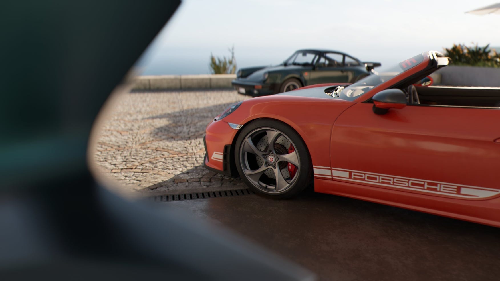 Close-up of a red Porsche 911 with detailed rims parked near a vintage car.