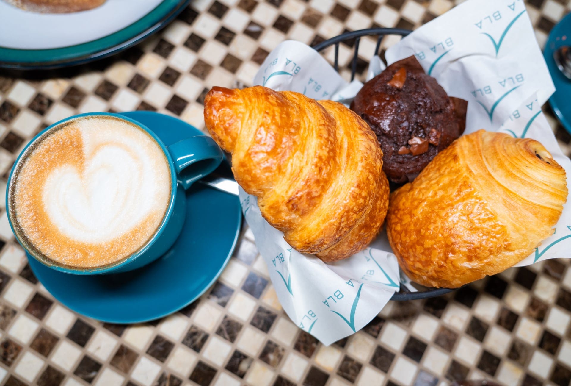 Breakfast spread with latte art and fresh croissants at a Dubai café