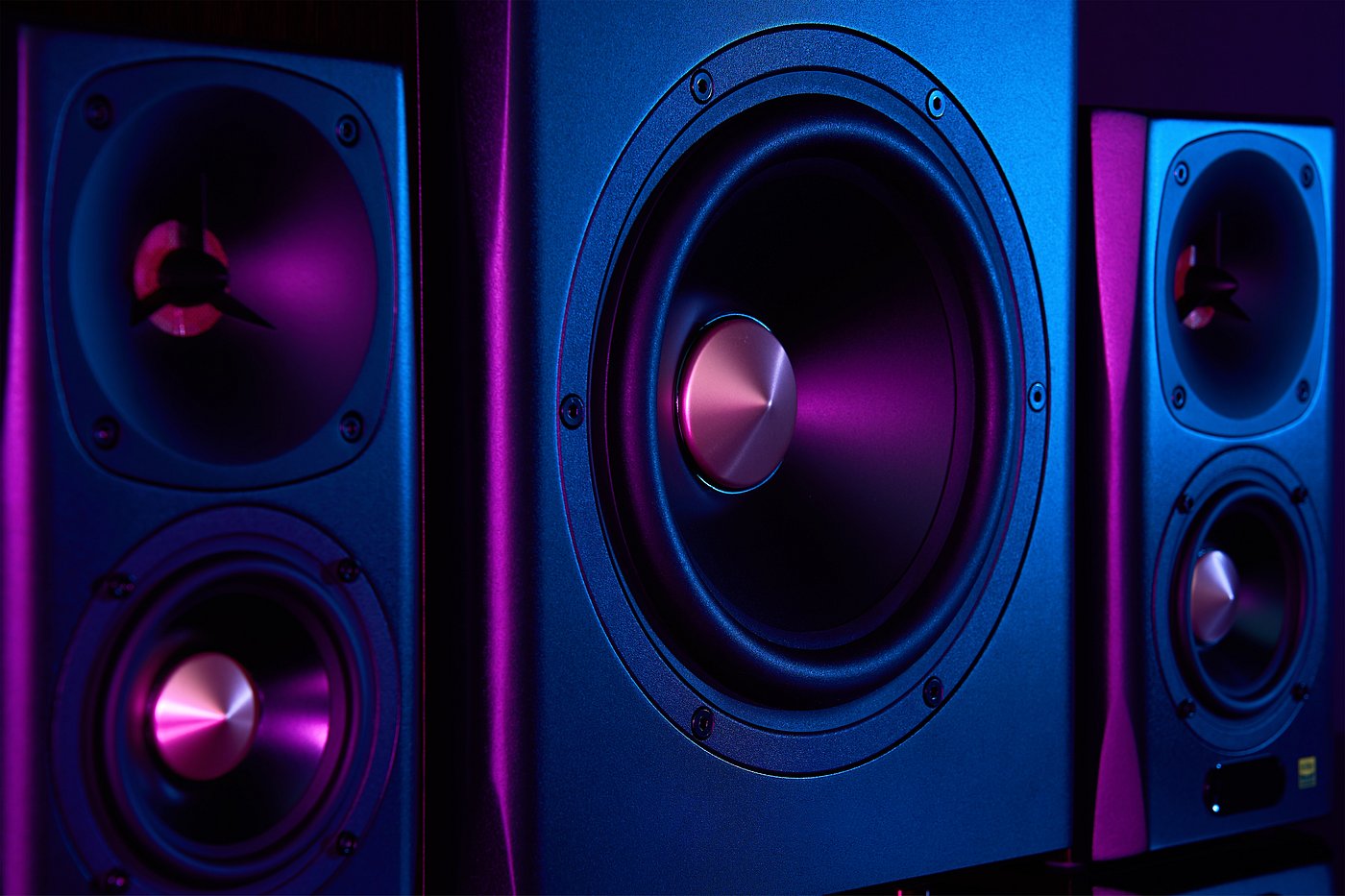 Close-up of a music speaker glowing under blue and purple light