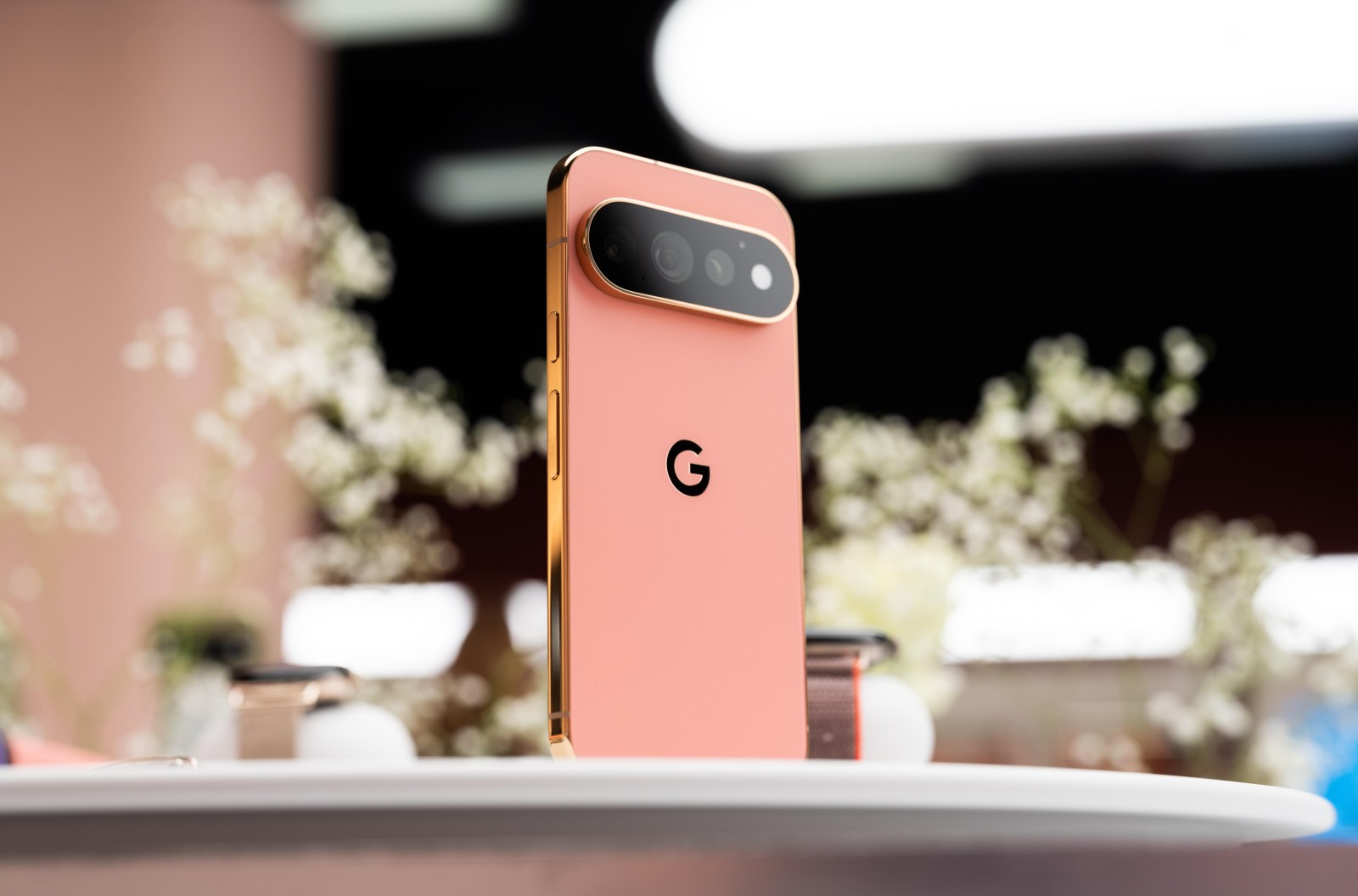 Google Pixel 11 in rose-gold standing upright, horizontal camera bar visible