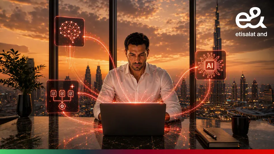 Professional using AI tools at a desk against a Dubai skyline with the e& logo