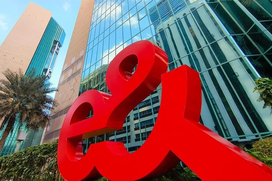 e& logo stands outside a modern glass-fronted office building