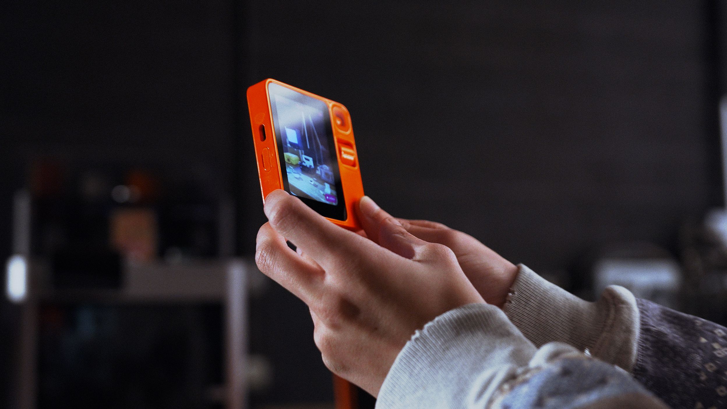 Rabbit R1 handheld device running Rabbit OS3 in a user's hands