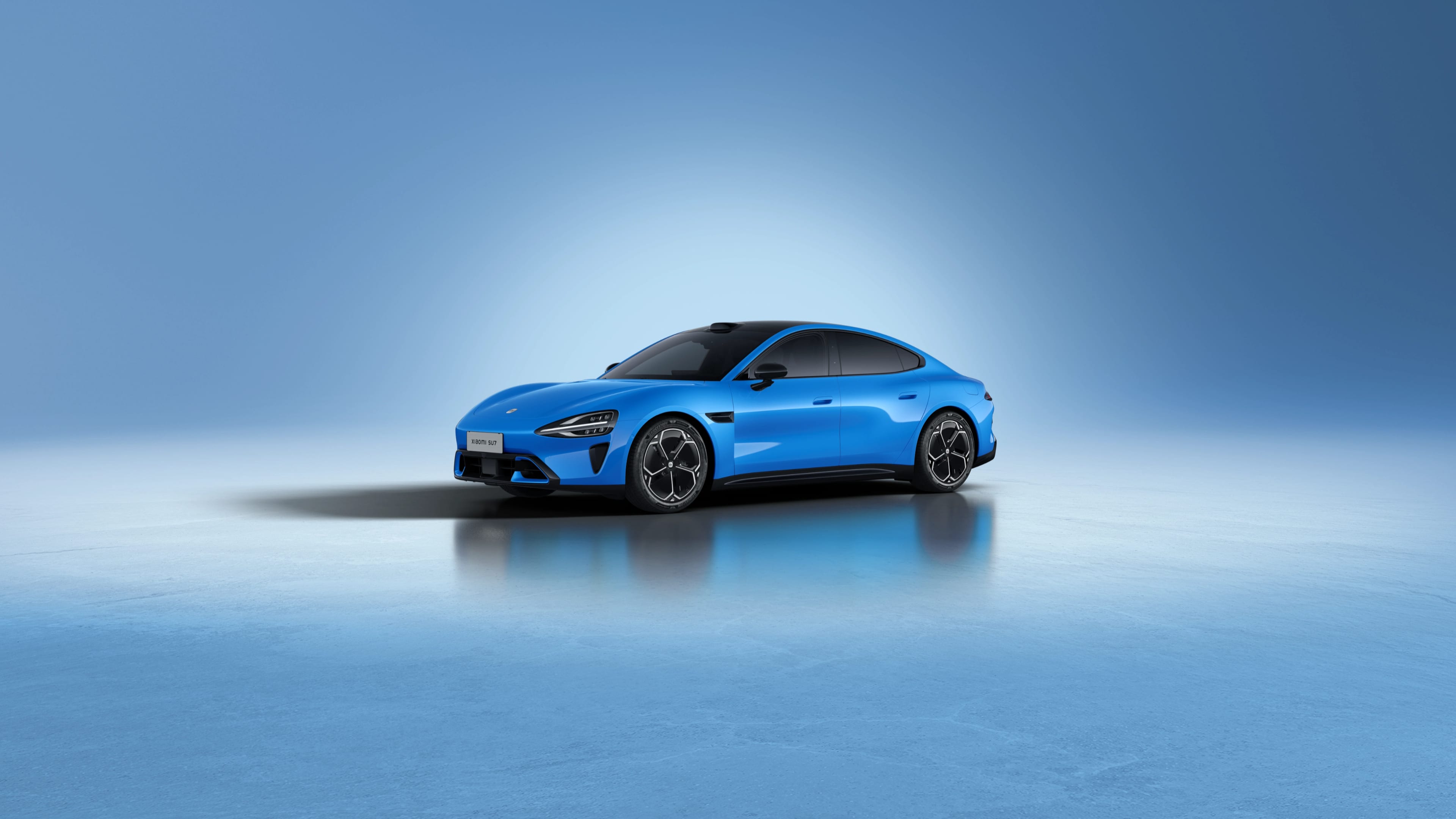 Blue Xiaomi SU7 electric sedan in a studio, front three-quarter view